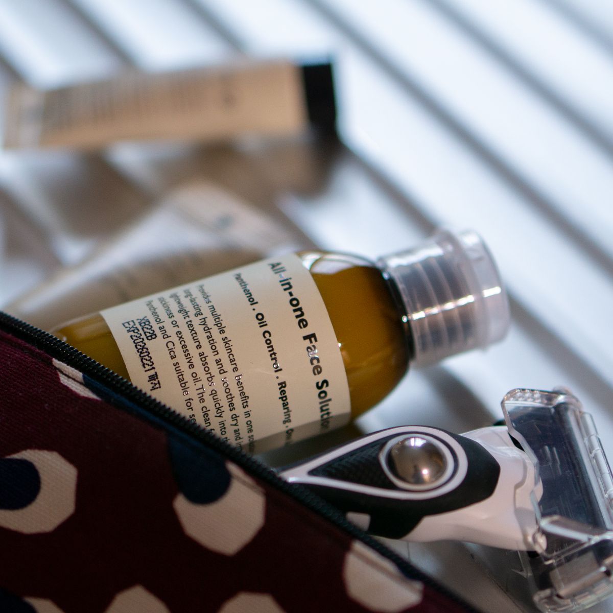 Gentleman Korea product shot featuring LAZY SOCIETY ALl-in-One Face Solution 50ml bottle in toiletry bag with razor