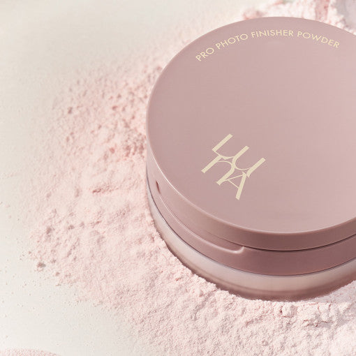 LUNA Pro Photo Finisher Pink Powder compact on a bed of loose pink powder, highlighting elegant package design.