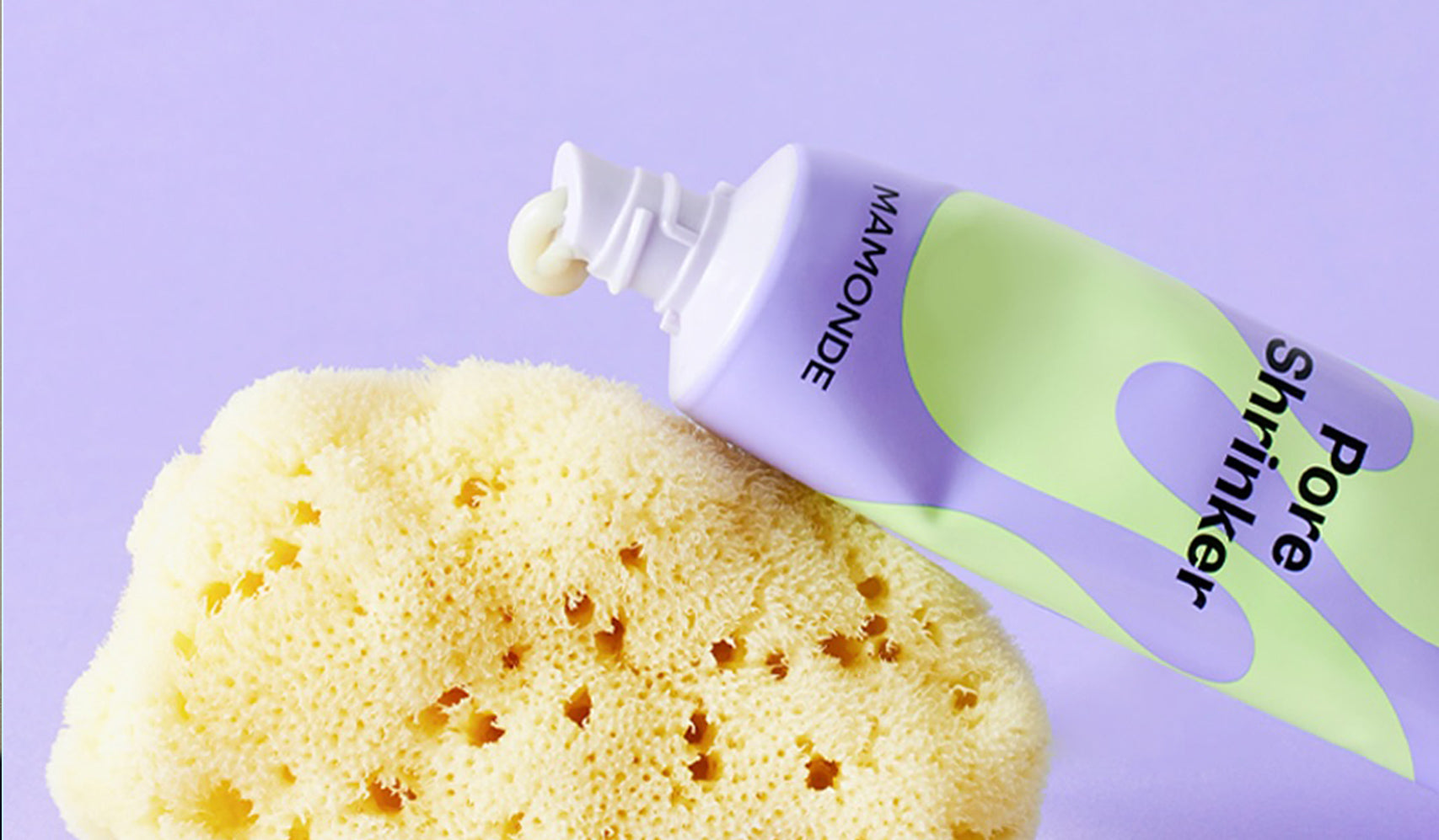 
Alt Tag: "Mamonde Pore Shrinker tube next to exfoliating sponge on purple background"