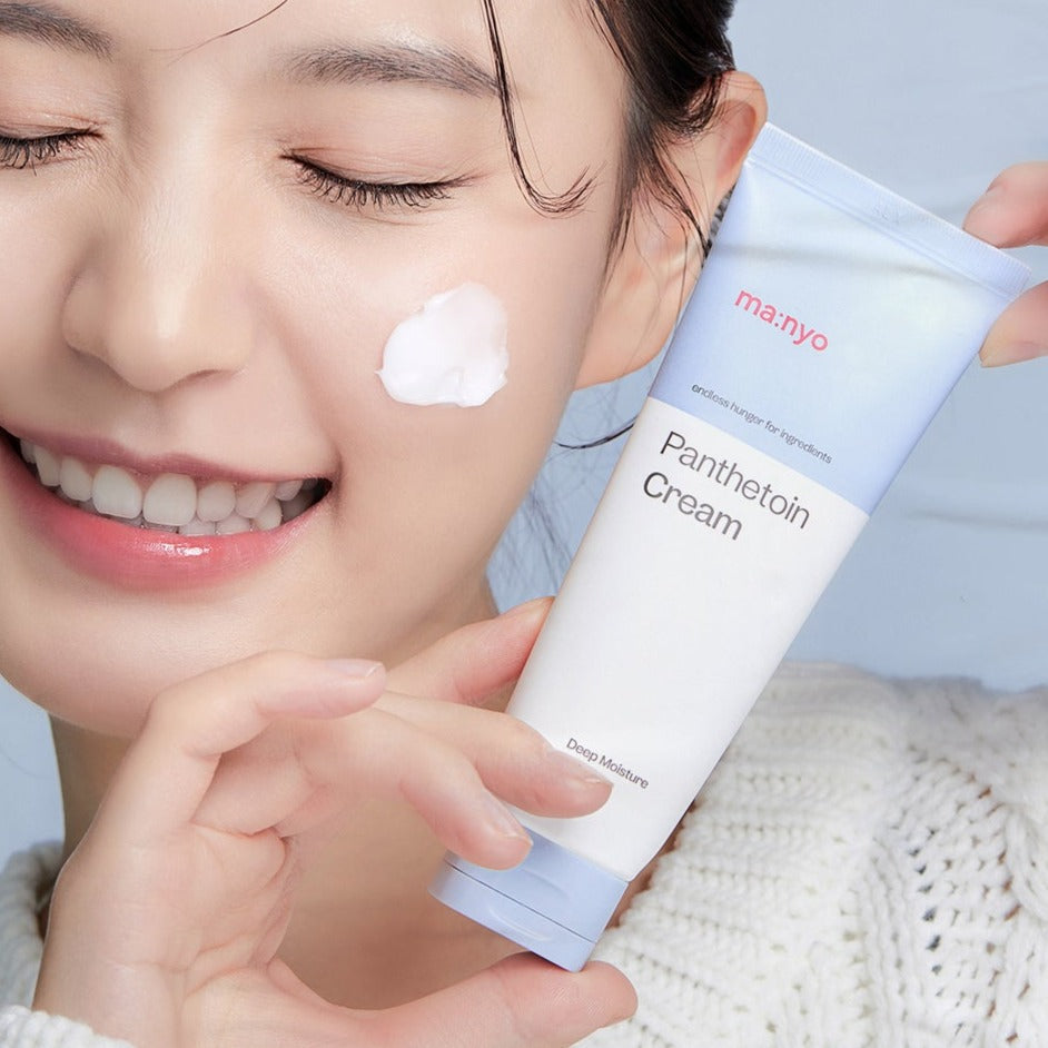 Woman applying MA:NYO Panthetoin Cream 80ml to her face, holding the product tube, showcasing skincare benefits.