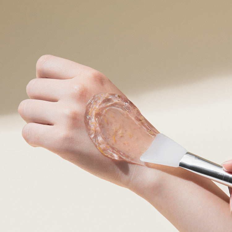 Application of MARY & MAY Calendula Peptide Ageless Sleeping Mask 110g on hand with spatula