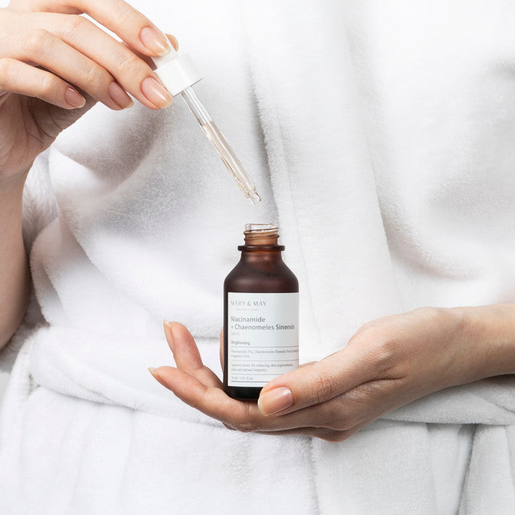 Applying MARY & MAY Niacinamide + Chaenomeless Sinensis Serum 30ml using a dropper