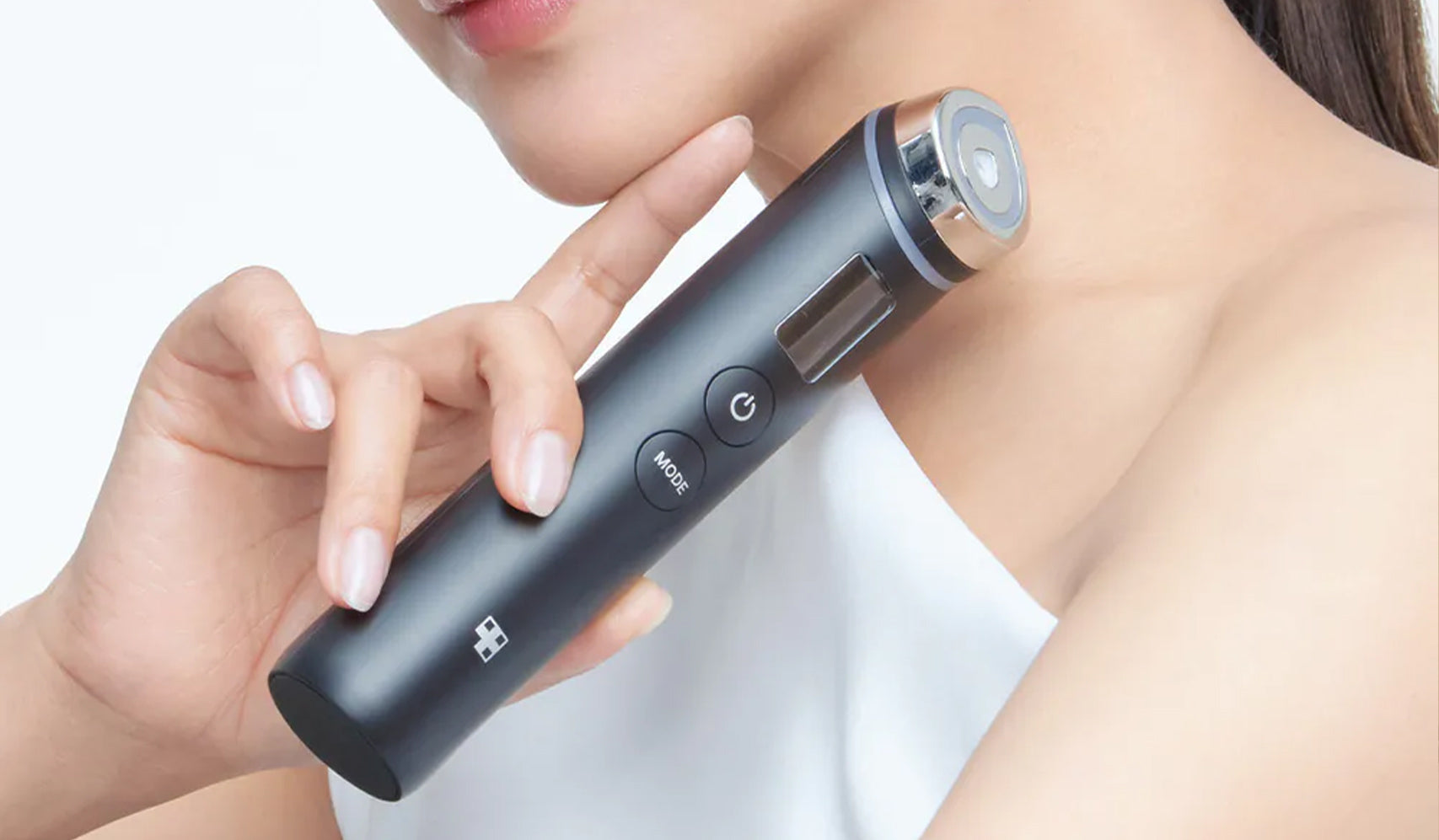 Woman demonstrating a handheld beauty device on her neck for skincare and rejuvenation.