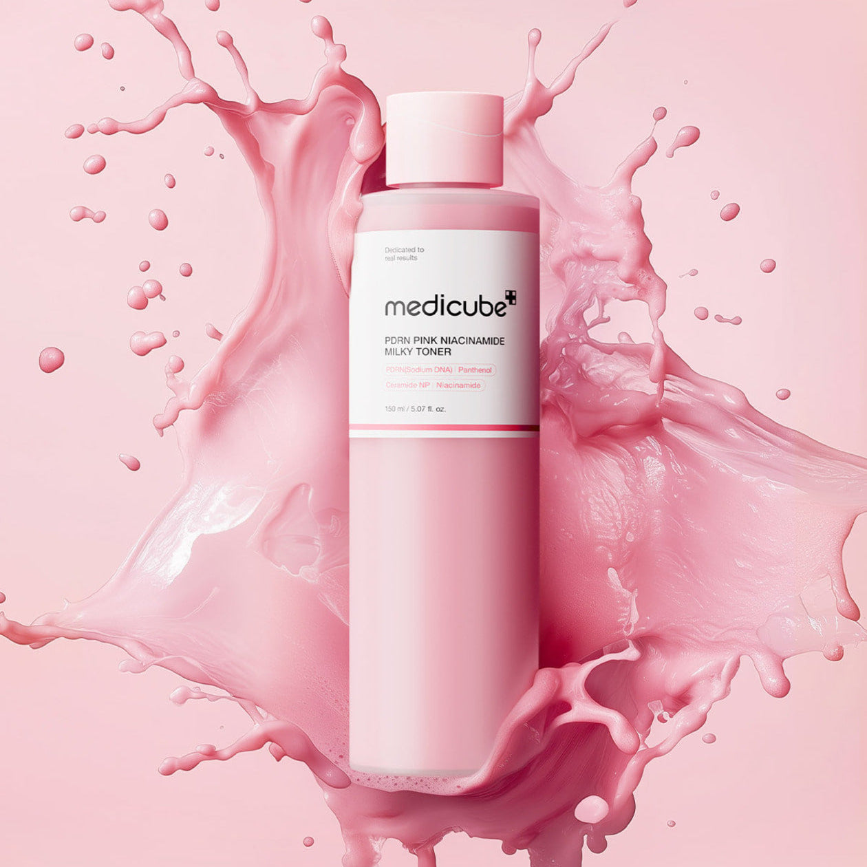 MEDICUBE PDRN Milky Toner Essence 150ml bottle on pink splash background showcasing skincare product packaging.