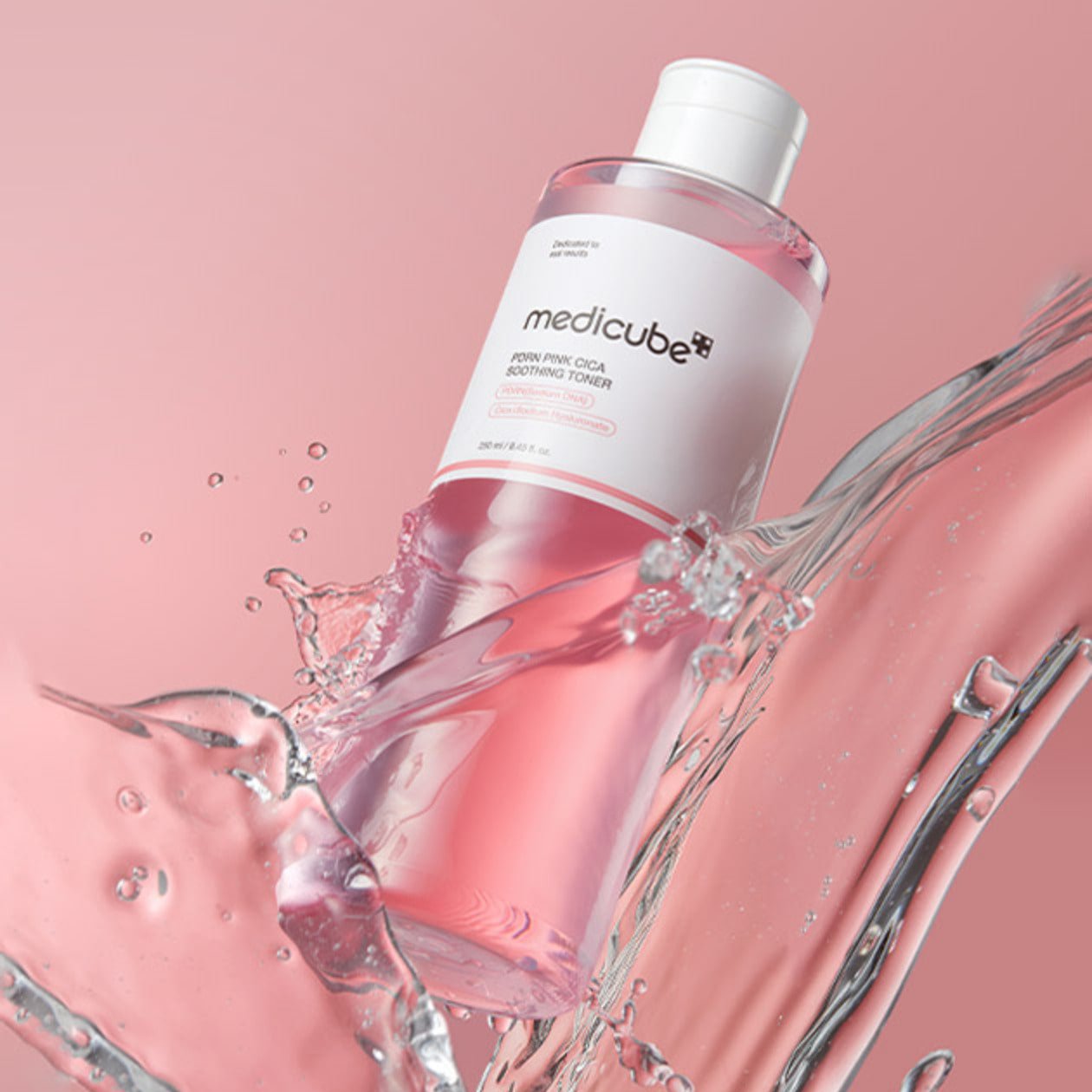 MEDICUBE PDRN Pink Cica Soothing Toner 250ml in splash effect with pink background