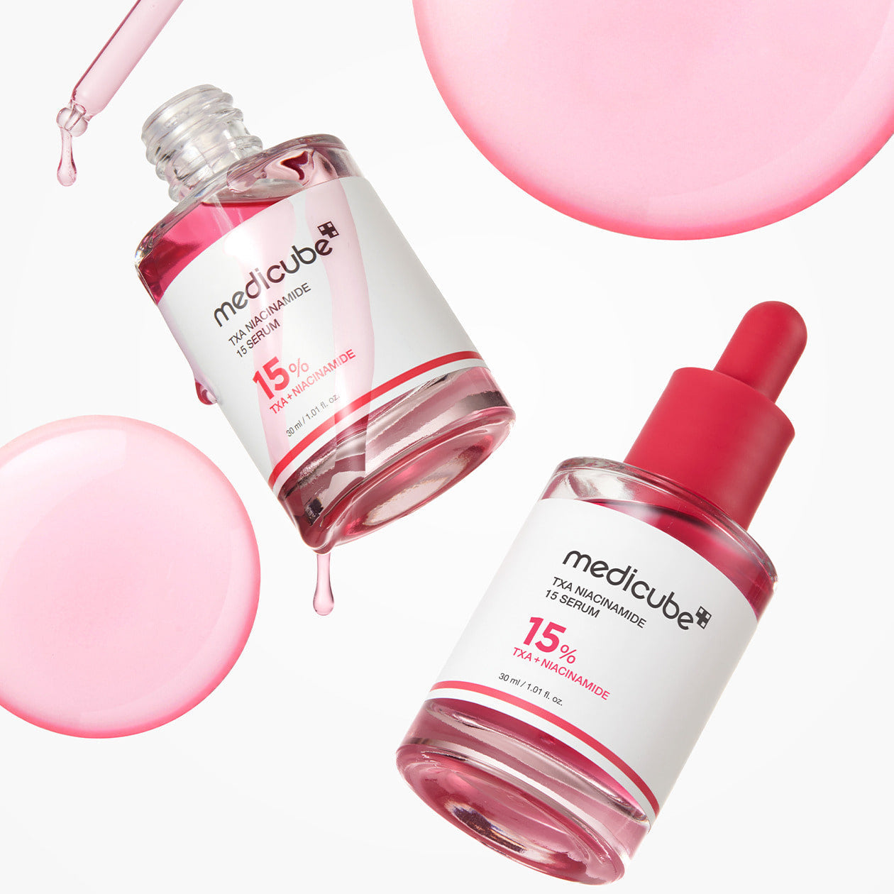 Image of MEDICUBE TXA Trace Toning Serum 30ml bottles and droplets, highlighting the skincare product.