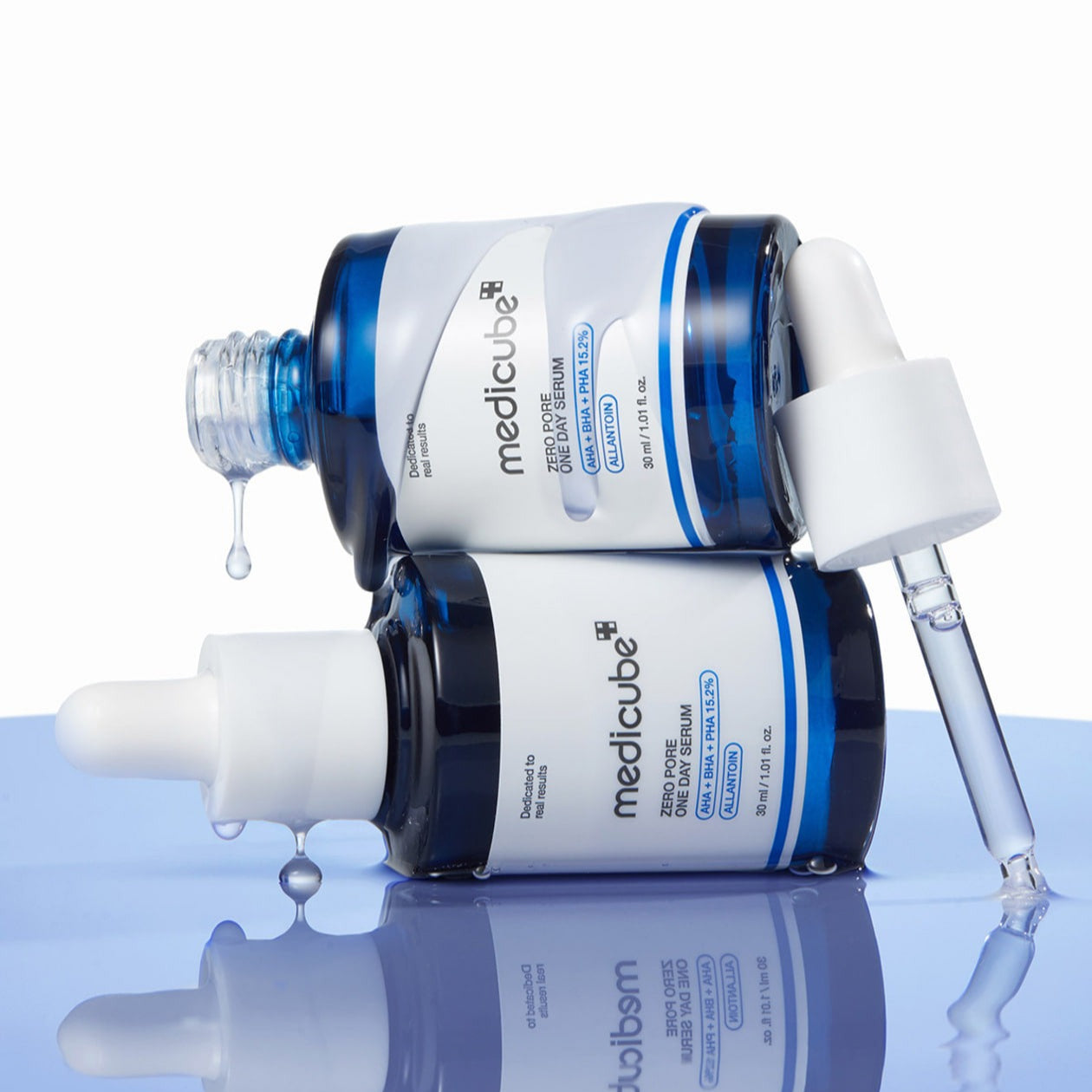 MEDICUBE Zero Pore One-Day Serum 30ml bottles on a reflective surface with open droppers.