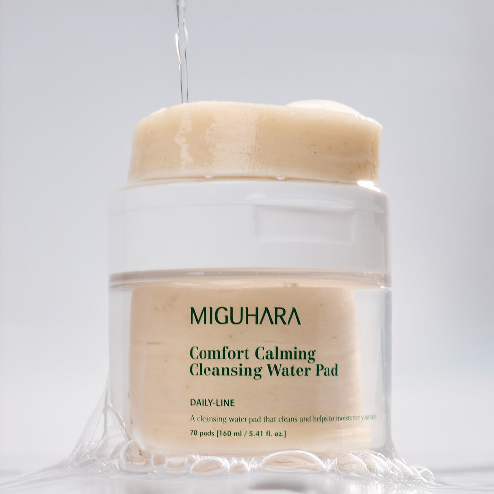 MIGUHARA Comfort Calming Cleansing Water Pads 70 Sheets in a clear container with cleansing water pouring down.