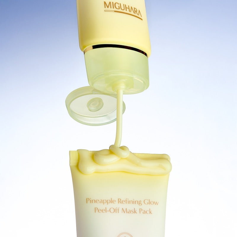 MIGUHARA Pineapple Refining Glow Peel Off Mask Pack 60ml being dispensed from tube against light blue background