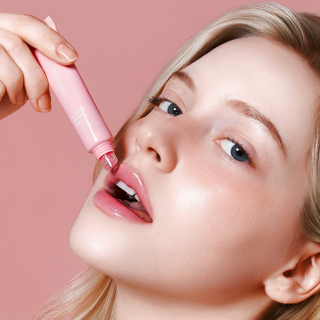Woman applying MILK TOUCH Glow Up Collagen Lip Balm 15g on lips for a radiant look.