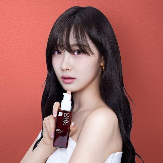 Woman holding MISE EN SCENE Perfect Serum 80ML against a red background