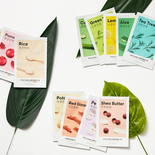 Selection of MISSHA Airy Fit Sheet Mask variants on leaves, showcasing diverse skincare benefits and natural ingredients.
