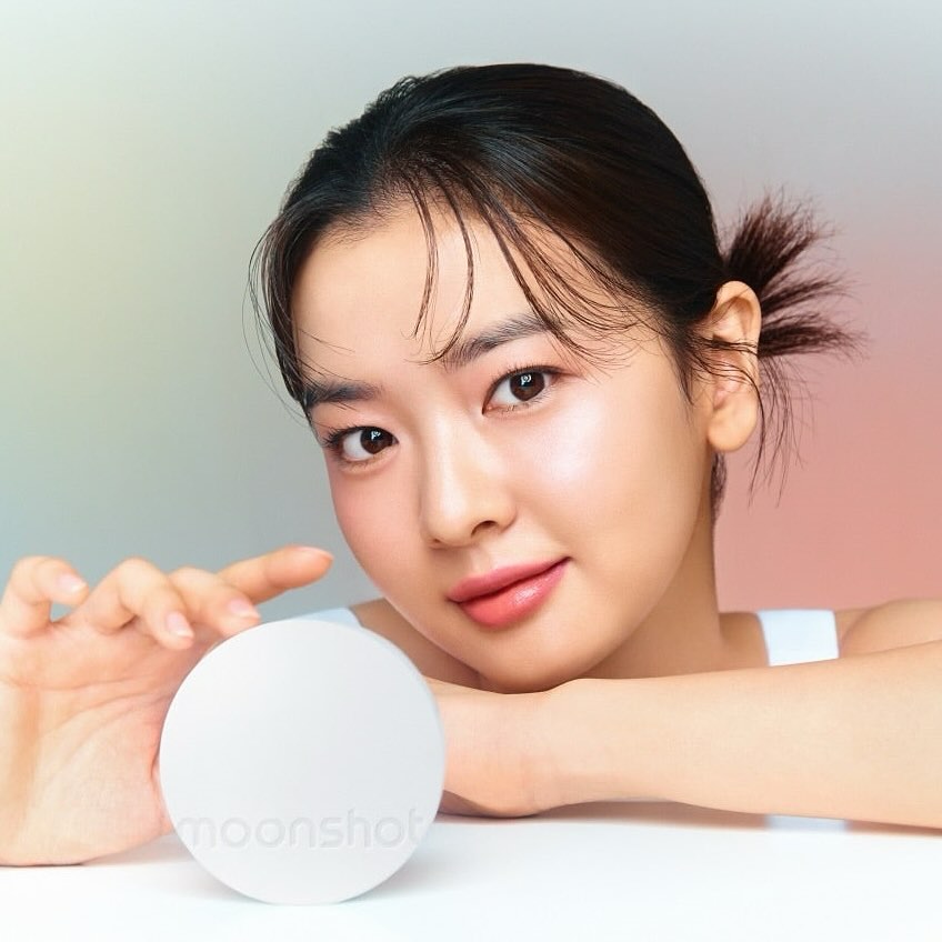Woman holding MOONSHOT Conscious Fit Glow Cushion Foundation with radiant skin