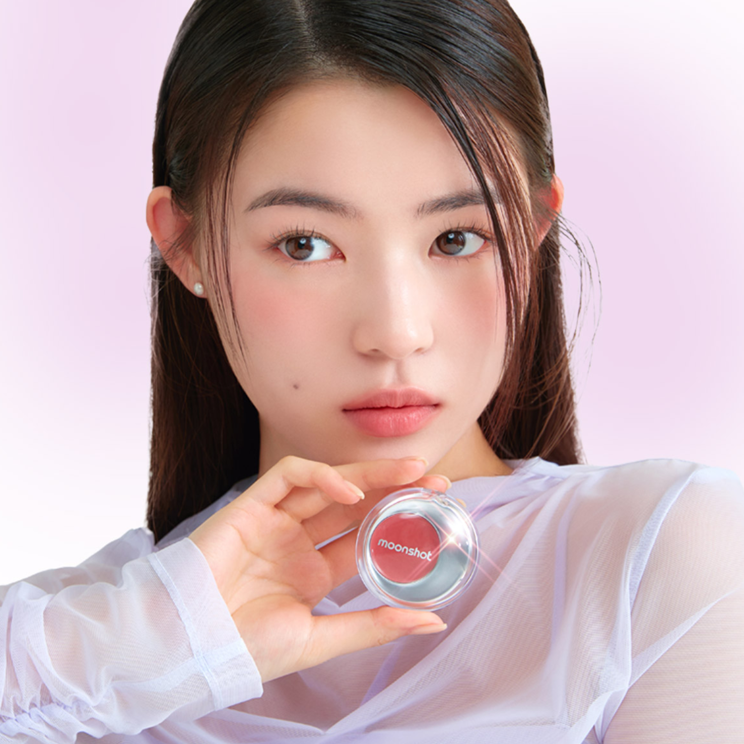 Person holding MOONSHOT Melting Mood Lip & Cheek product, showcasing vibrant lip and cheek color in a stylish packaging