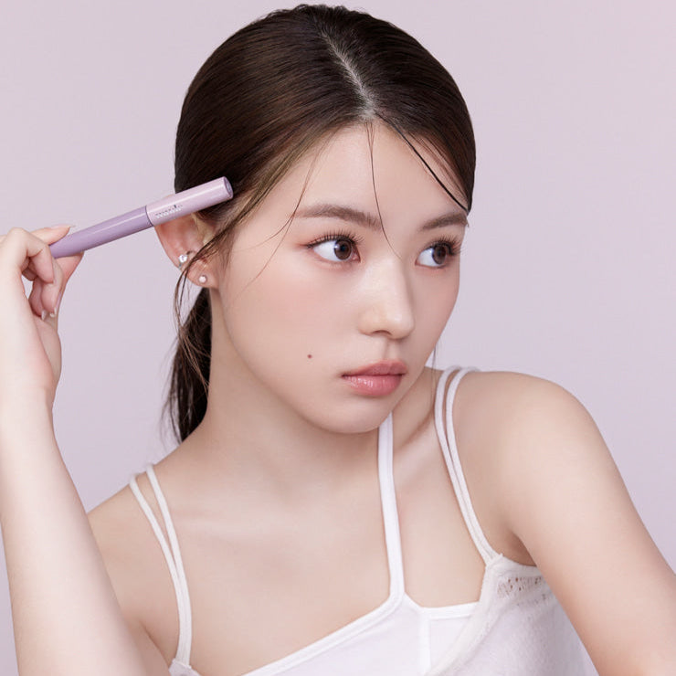 Woman holding MUDE Inspire Skinny Brow Cara for precise eyebrow styling.