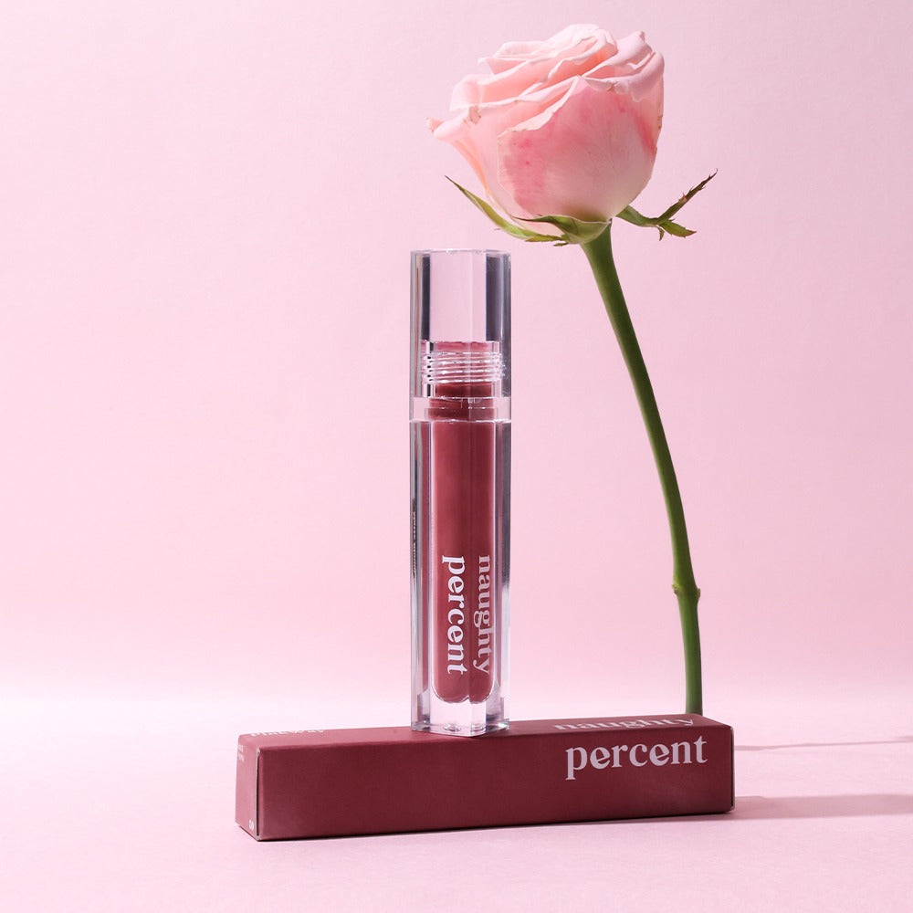 NAUGHTY PERCENT Matte Bloom Tint with rose on a pink background.