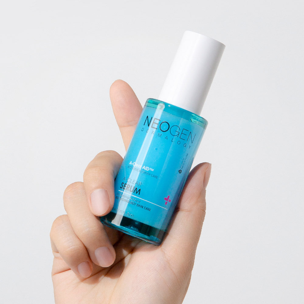 Hand holding NEOGEN A Clear Serum 30ml bottle showcasing skincare product design and label.