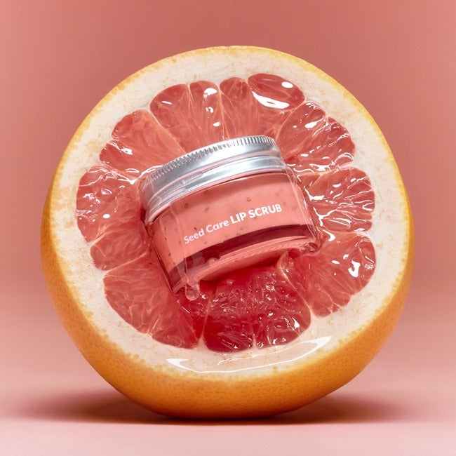 NUSE Seed Care Lip Scrub displayed on a halved grapefruit, showcasing the lip scrub product's natural ingredients and nourishing care.