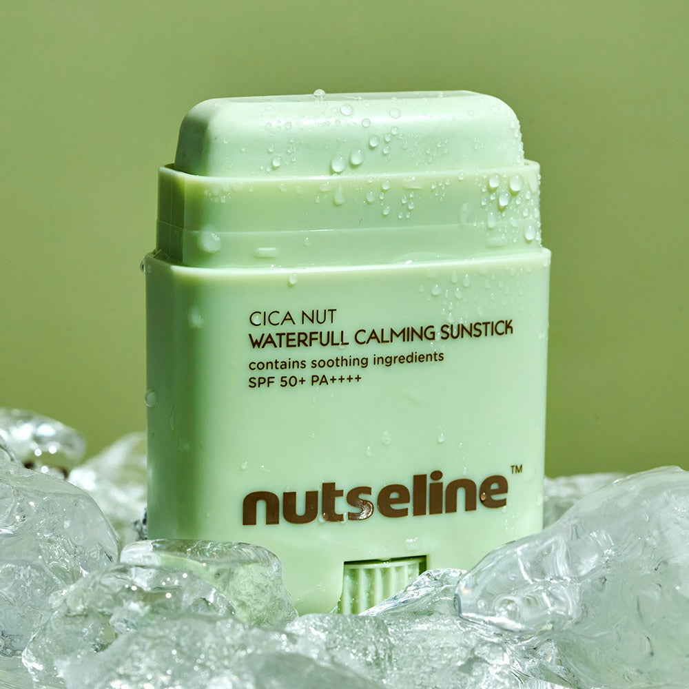 NUTSELINE Cica Nut Waterful Calming Sun Stick 20g resting on ice, showcasing its soothing ingredients and SPF 50+ protection.