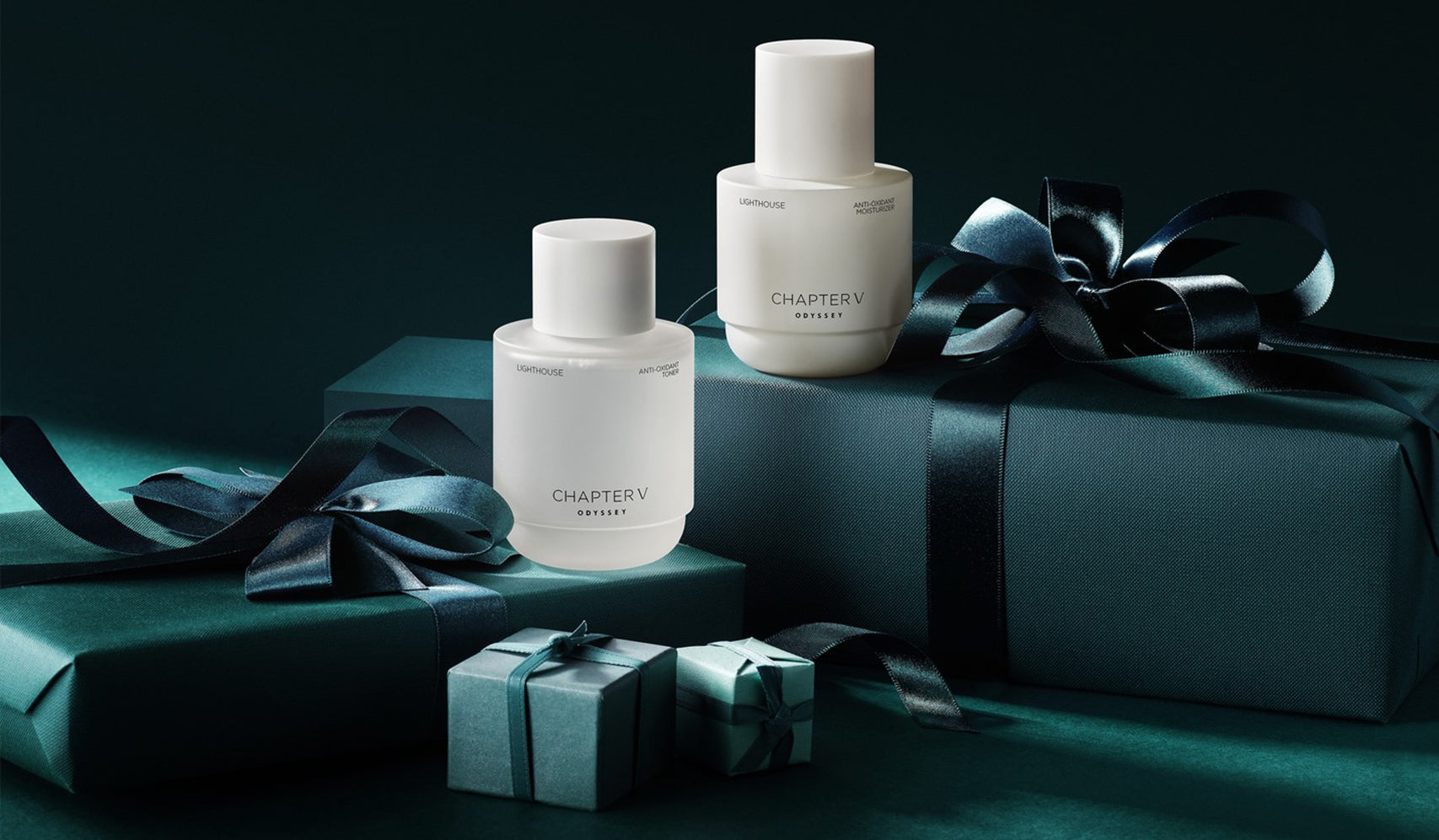 Luxury perfume bottles displayed with elegant gift boxes and dark satin ribbons on a teal background, perfect for a sophisticated present.