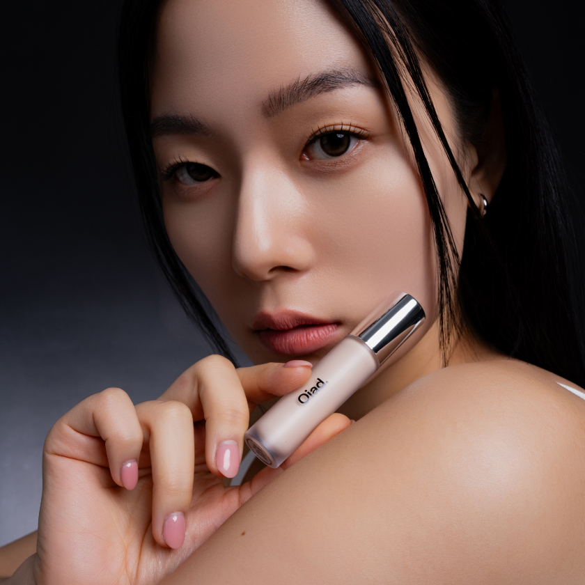 Woman holding OIAD Cover Perfecting Mirror Brushed Concealer showcasing flawless skin results