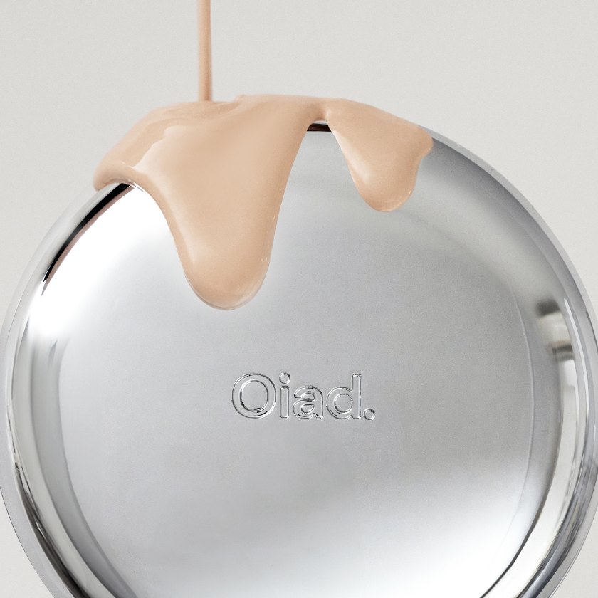 OIAD Pore Perfecting Mirror Moon Cushion makeup compact with liquid foundation pouring over the silver surface