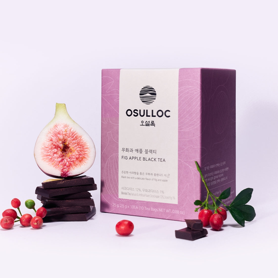 OSULLOC Fig Apple Black Tea 10 P with fig, apple, and tea packaging next to fresh fruit and chocolate pieces.