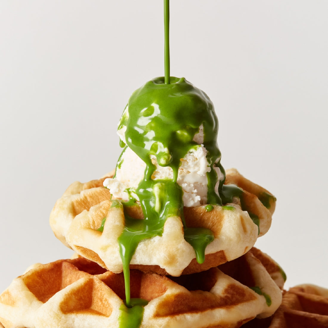 Stack of waffles topped with ice cream and OSULLOC Green Tea Milk Spread 200g drizzling down for a delicious treat.