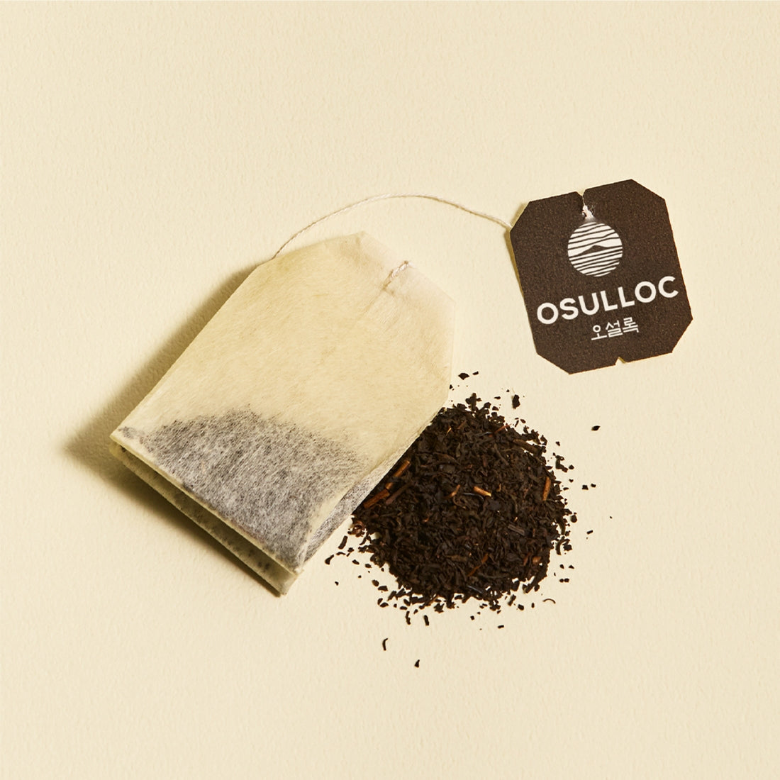 OSULLOC Yuja Earl Grey 20 p tea bag with loose tea leaves on a light background.