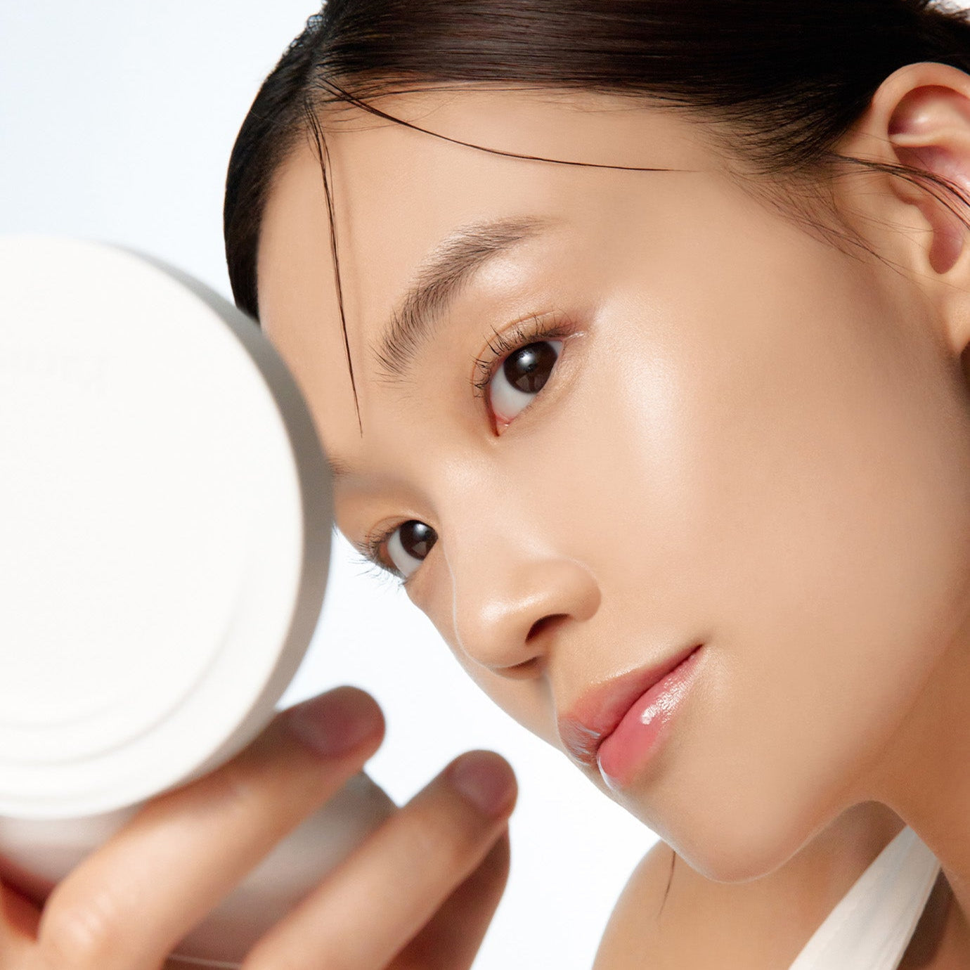 Woman holding PARNELL Cicamanu Serum Cushion 15g, highlighting skincare benefits. Perfect for a radiant, natural makeup look.