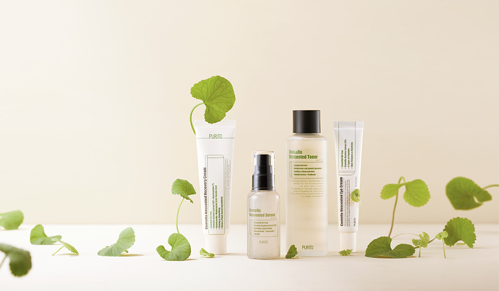 Skincare product lineup with natural ingredients on a neutral background with green leaves.