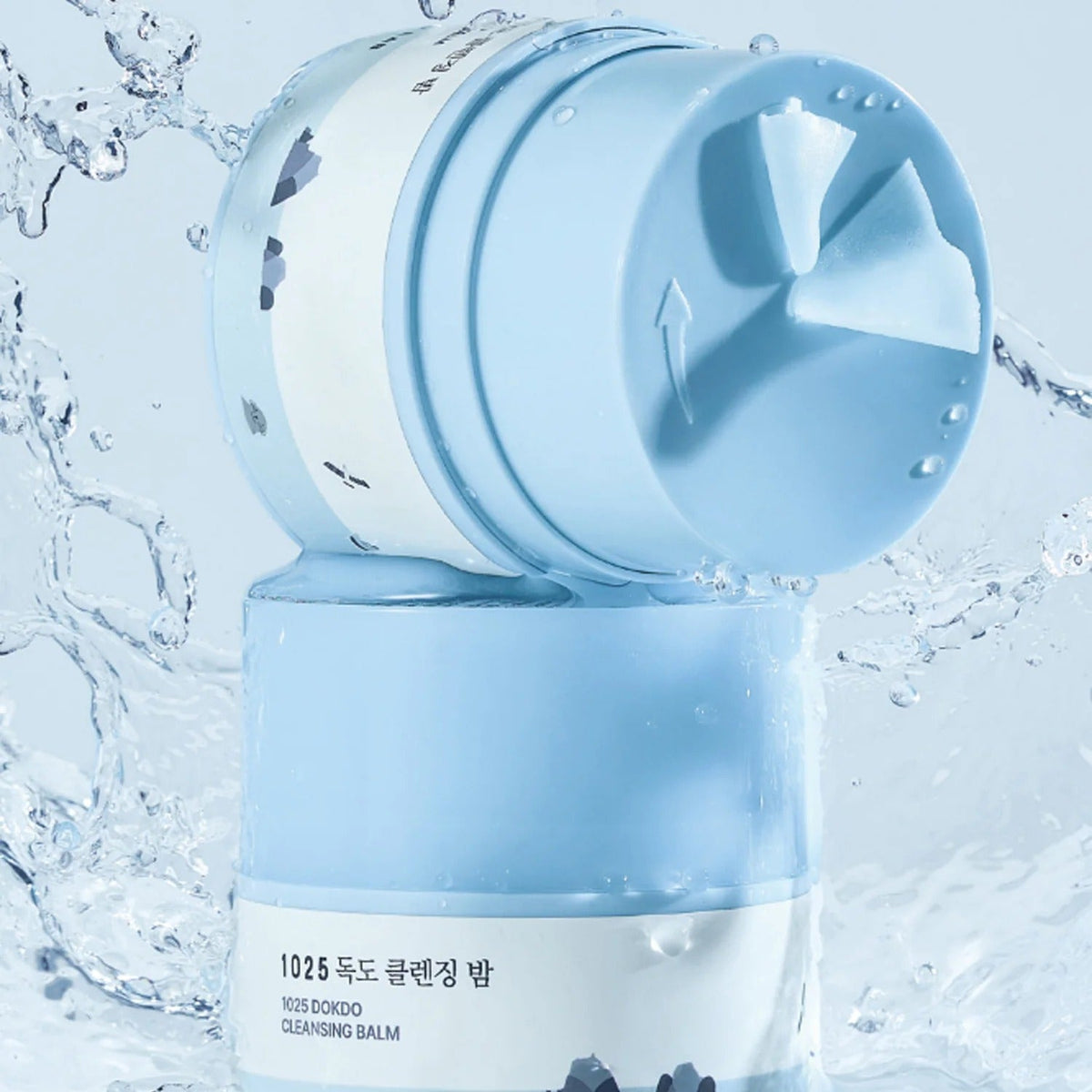 ROUND LAB 1025 Dokdo Cleansing Balm 50ml product image with blue packaging in a watery background.