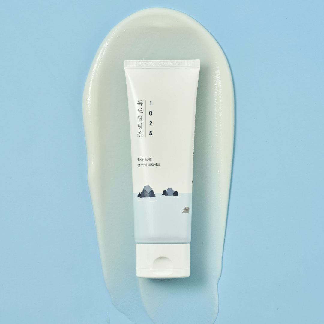 Image of ROUND LAB 1025 Dokdo Peeling Gel 120ml tube on a blue background with gel smear.
