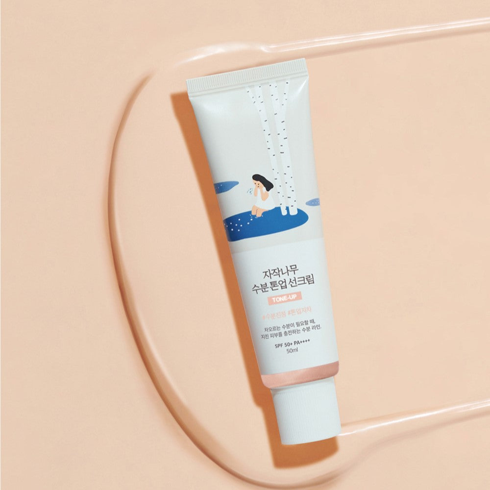 ROUND LAB Birch Juice Moisturizing Tone-up Sunscreen 50ml on beige background with illustration on tube.