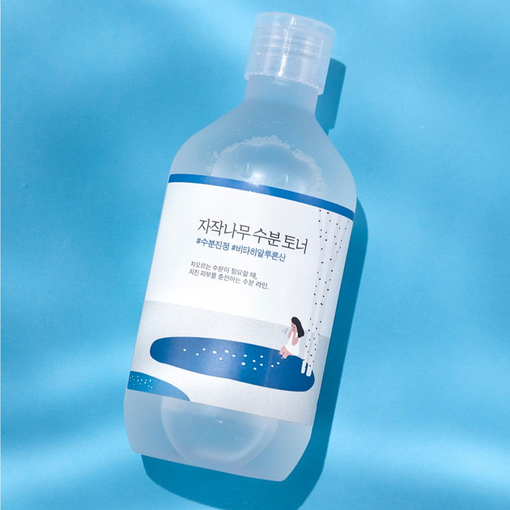 Image of ROUND LAB Birch Juice Moisturizing Toner 300ml bottle on a blue background.