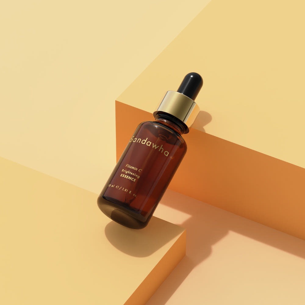 SANDAWHA Vitamin C Whitening Essence 30ml bottle on a geometric yellow background