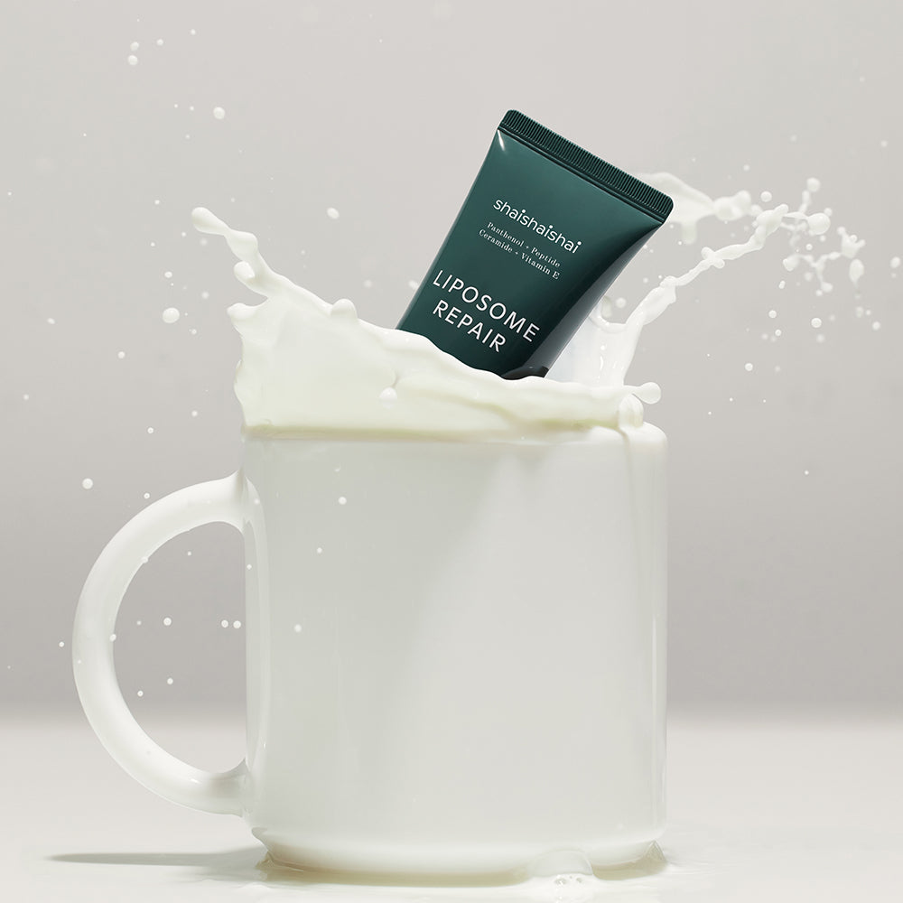 SHAISHAISHAI Liposome Repair Milky Cream 50ml sitting in a splash of milk inside a white mug.
