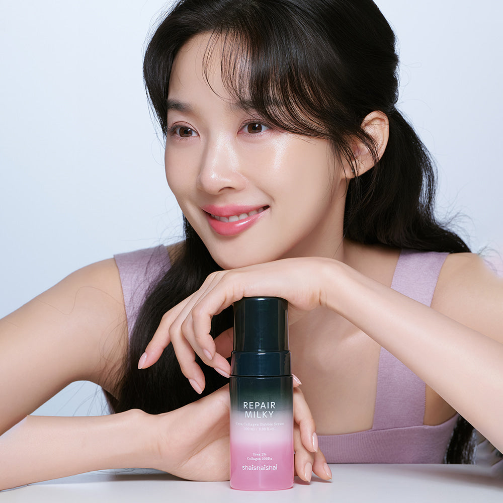 Woman holding SHAISHAISHAI Repair Milky Urea Glow Bubble Serum 100ml bottle, showcasing skincare product.