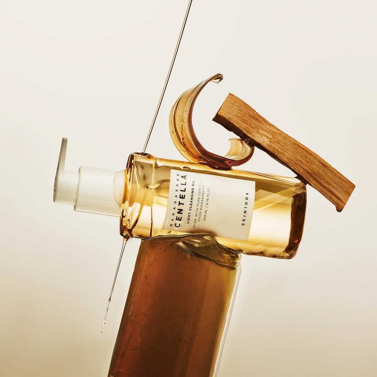 Bottle of SKIN1004 Madagascar Centella Light Cleansing Oil 200ml with elegant design display on neutral background.
