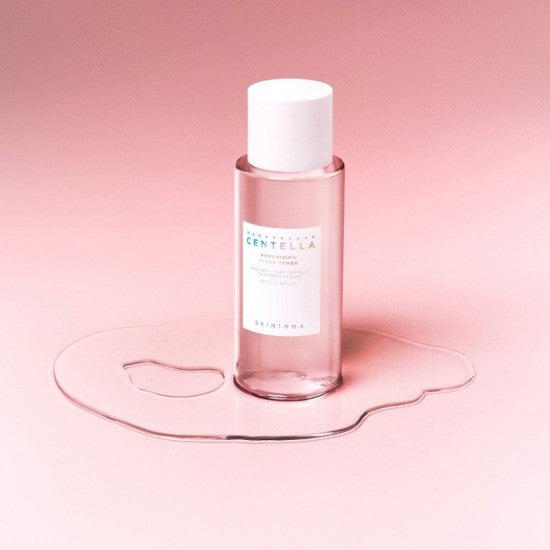 SKIN1004 Madagascar Centella Poremizing Clear Toner 210ml bottle on a pink background with liquid spill