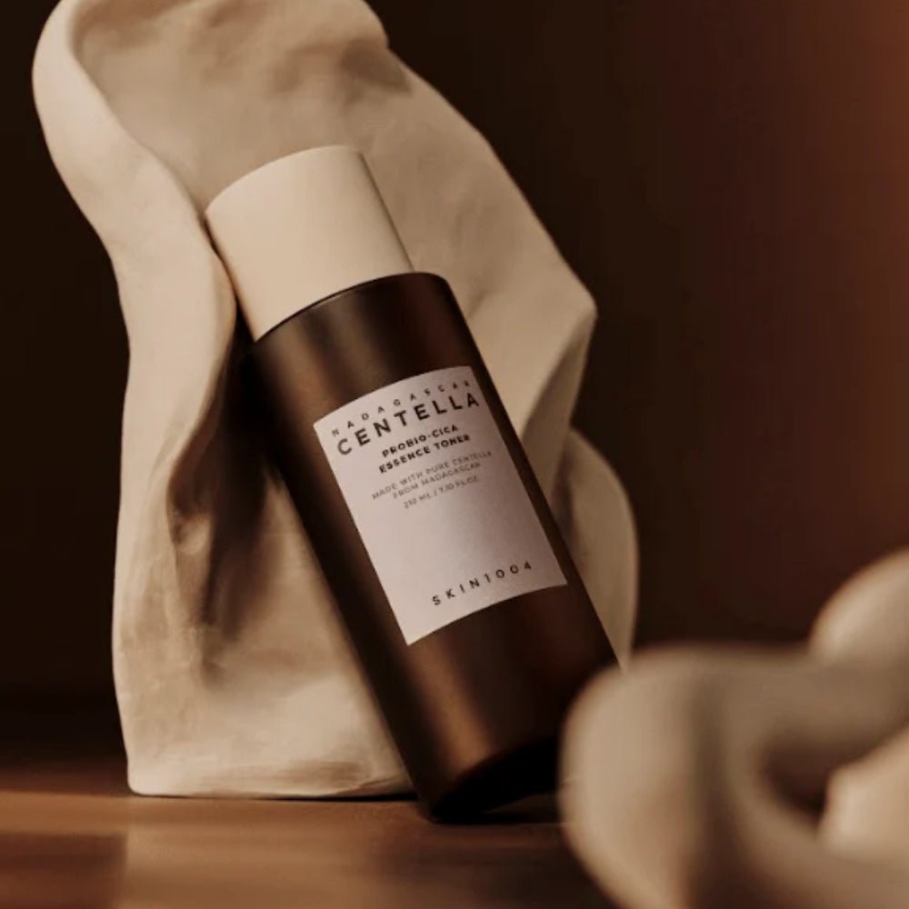 SKIN1004 Madagascar Centella Probio-cica Essence Toner 210ml bottle on display with elegant fabric backdrop