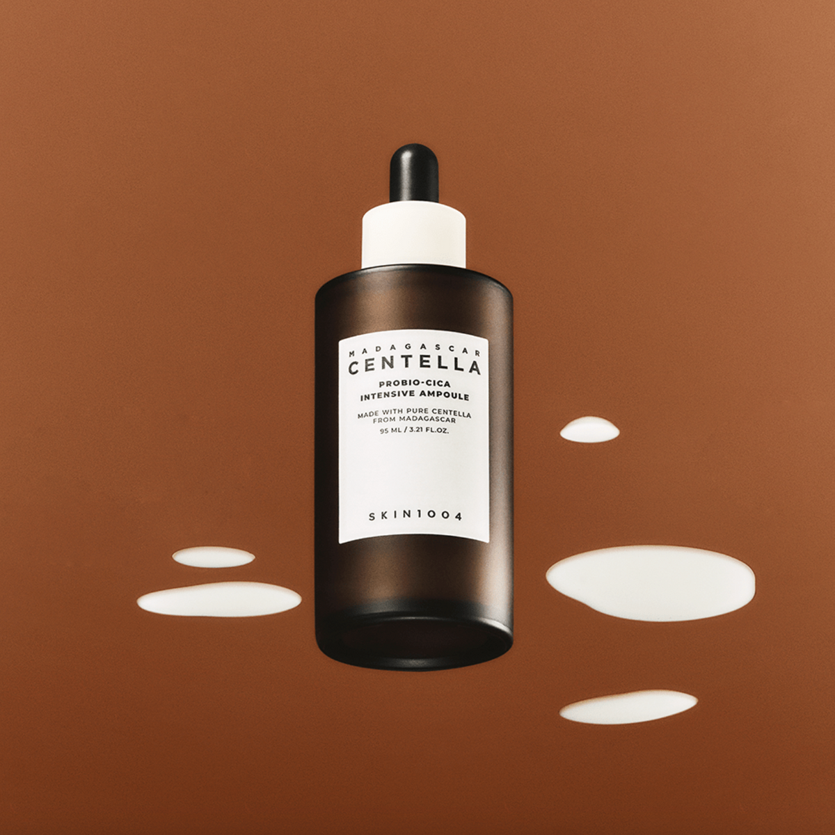 SKIN1004 Madagascar Centella Probio-cica Intensive Ampoule 95ml bottle on brown background with liquid drops