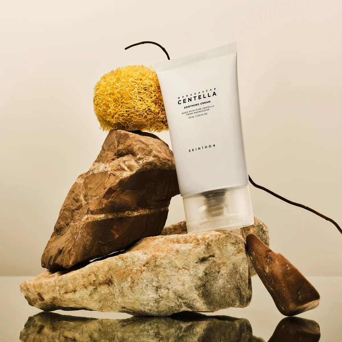 Image of SKIN1004 Madagascar Centella Soothing Cream 75ml tube displayed on natural rocks.