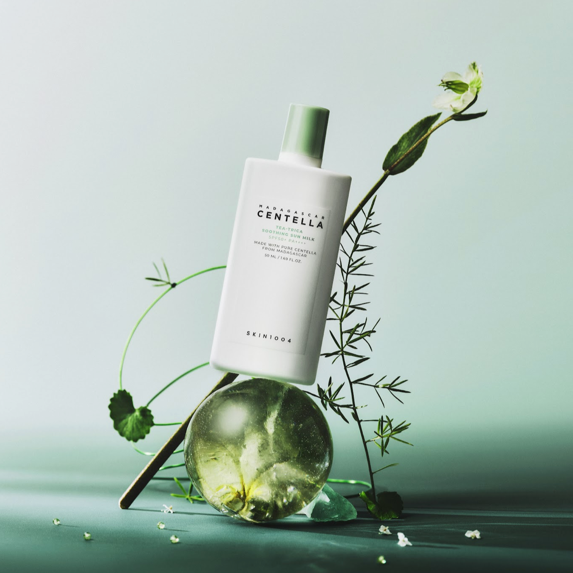 SKIN1004 Madagascar Centella Tea-trica Soothing Sun Milk 50ml bottle with natural elements displayed elegantly