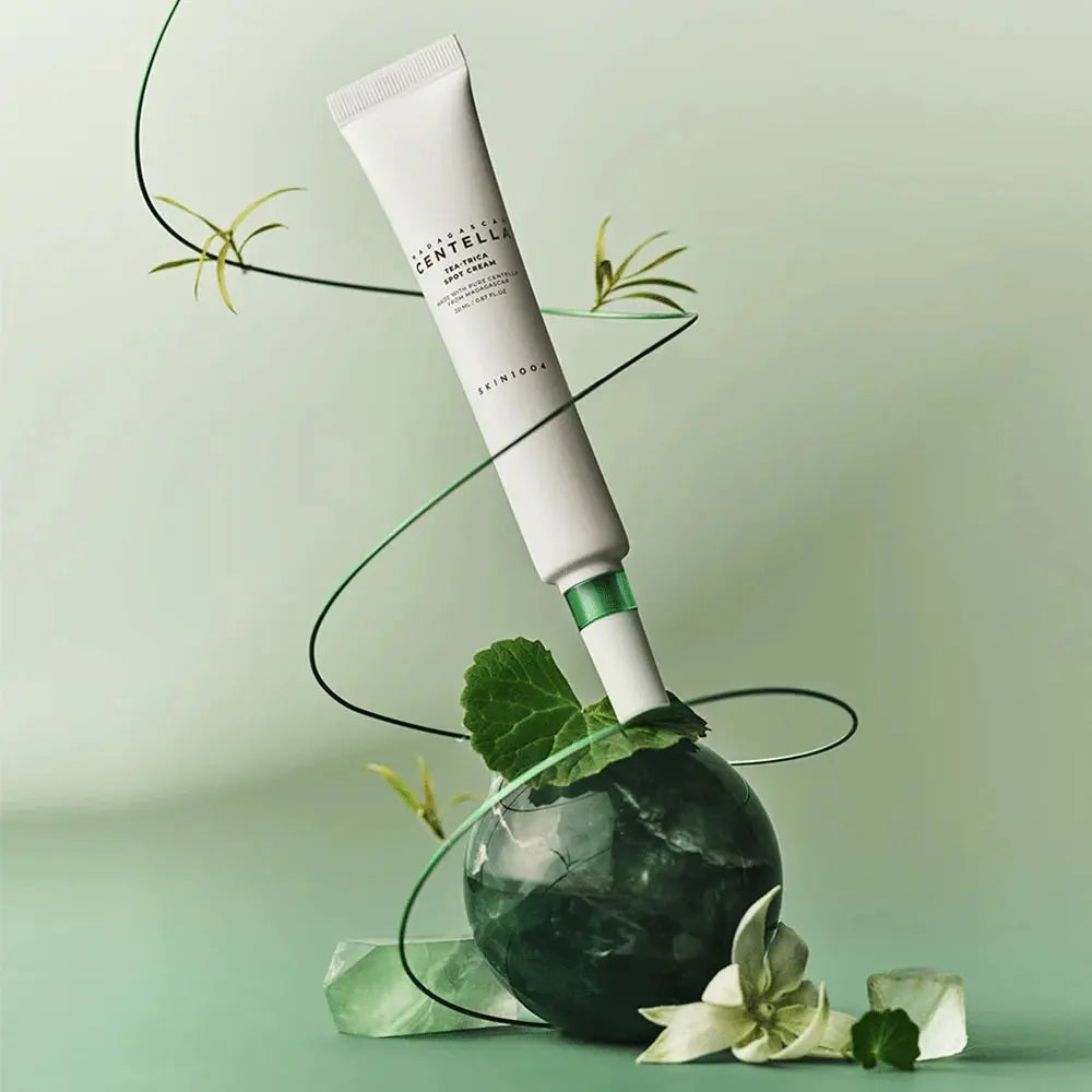 SKIN1004 Madagascar Centella Tea-trica Spot Cream 20ml displayed creatively with green and floral elements.