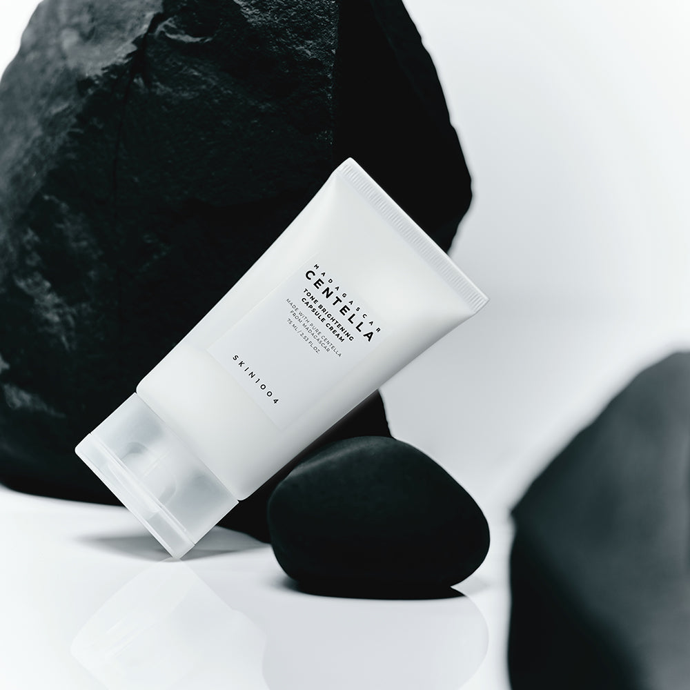 SKIN1004 Madagascar Centella Tone Brightening Capsule Cream 75ml product tube on a minimalist rock background.