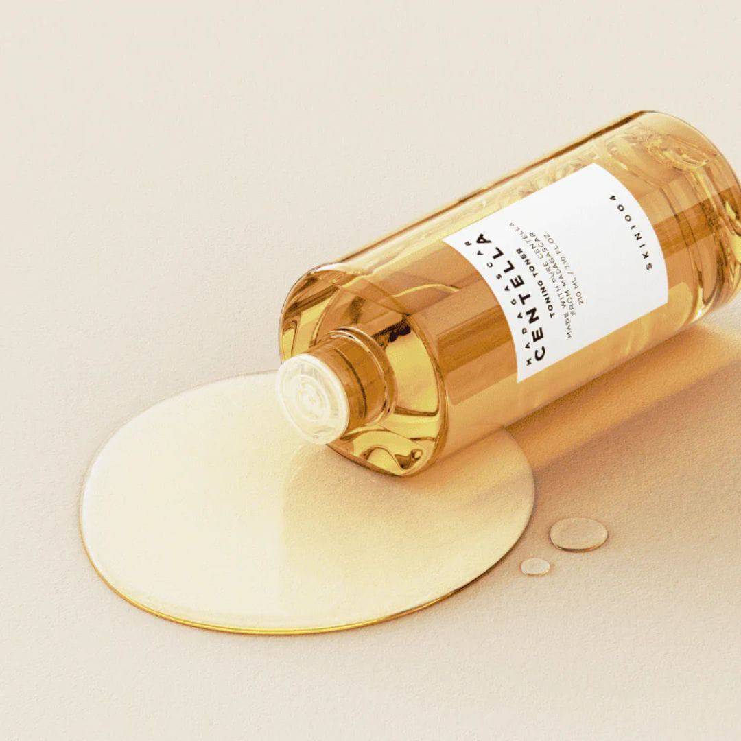 SKIN1004 Madagascar Centella Toning Toner 400ml bottle with liquid spread on a light background.