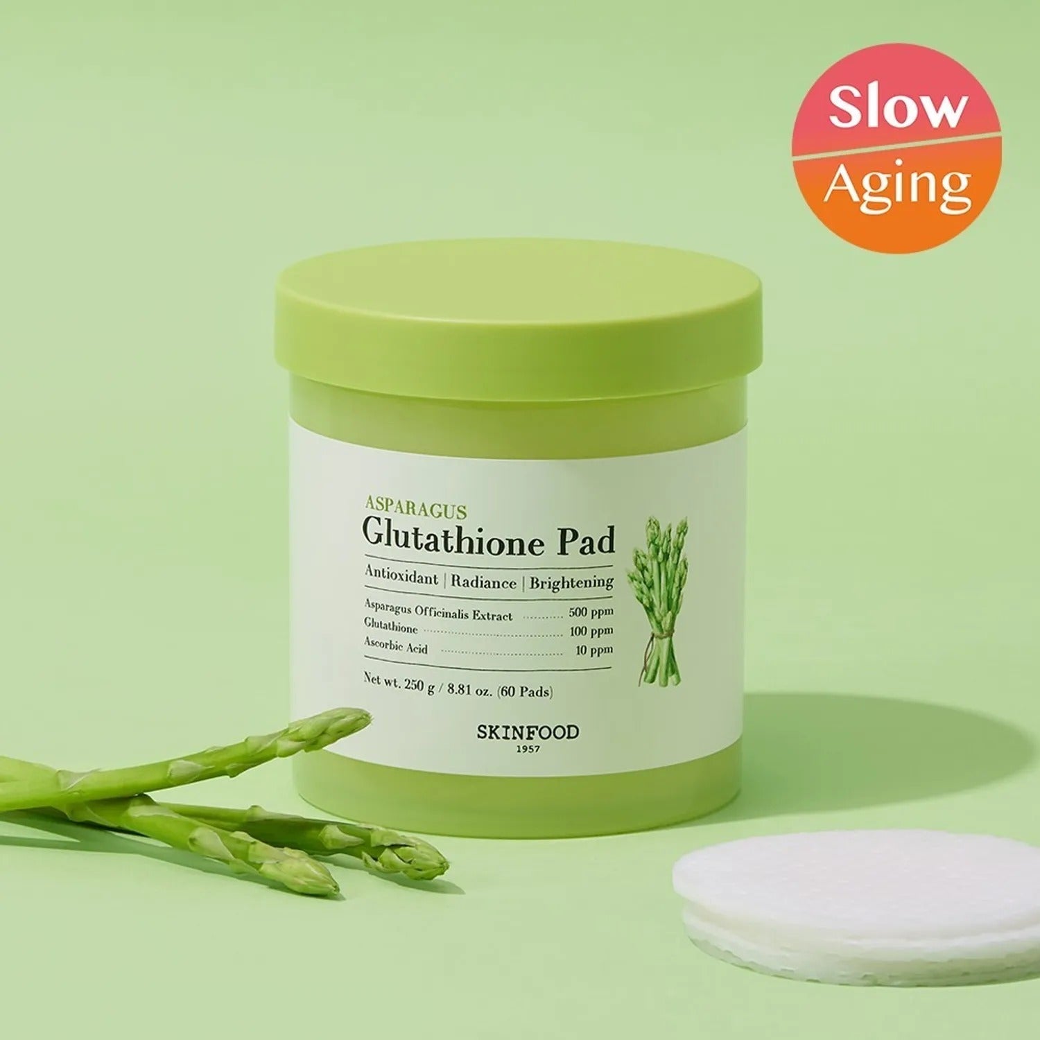 SKINFOOD Asparagus Glutathione Pad (60 Pads) with slow aging benefits and fresh asparagus on a green background