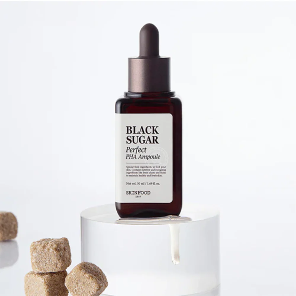 SKINFOOD Black Sugar Perfect PHA Ampoule 50ml bottle with sugar cubes, showcasing the product's exfoliating properties.