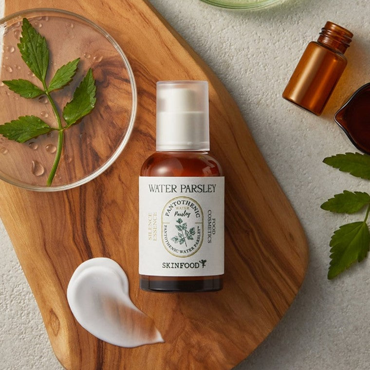 SKINFOOD Pantothenic Water Parsley Silence Essence 50ml bottle on a wooden tray with parsley leaves and skincare samples